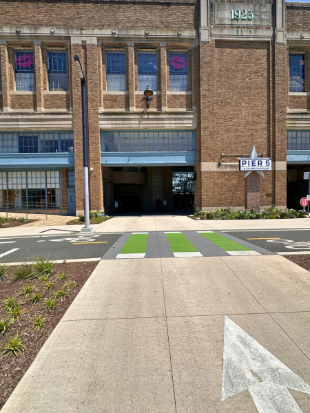 Green-striped pedestrian crosswalk and arrow leading to the main entrance of Pier 5 Municipal Pier, 7 N Christopher Columbus Blvd.